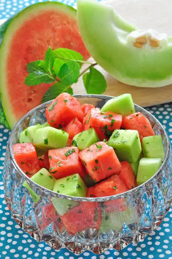 glass bowl with chopped melon and mint