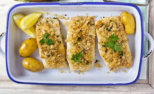 white plate with oven fried fish and lemon