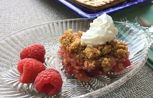 glass plate with slice of rhubarb cobbler and whipped cream