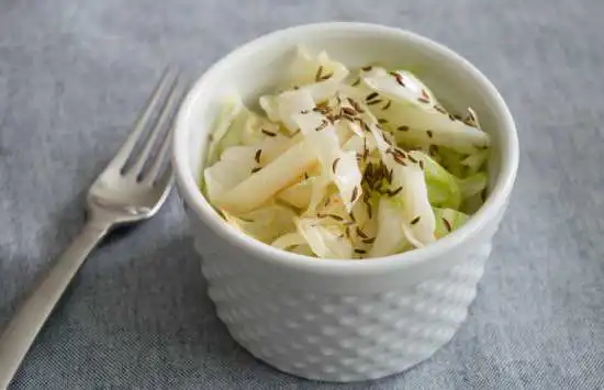 small white dish of sauteed cabbage with onions