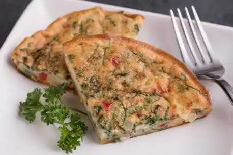 two triangles of quiche on a plate with a fork