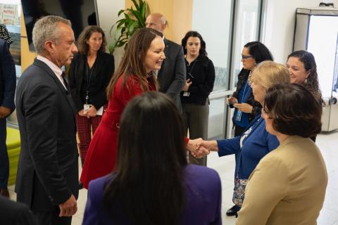 Brook Rollins shaking a school staff person's hand while Kennedy looks on.