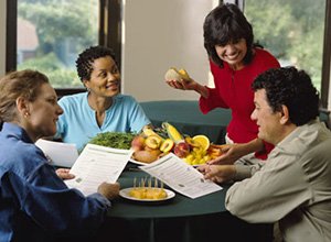 woman teaching a nutrition education class to adults around a table