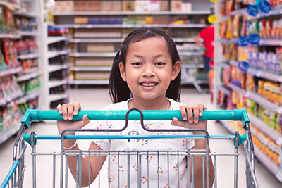 girl pushing a shopping cart in a grocery store
