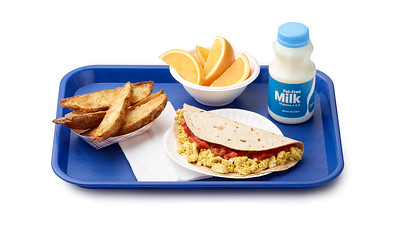 school lunch tray featuring a tofu taco, potatoes, oranges, and milk