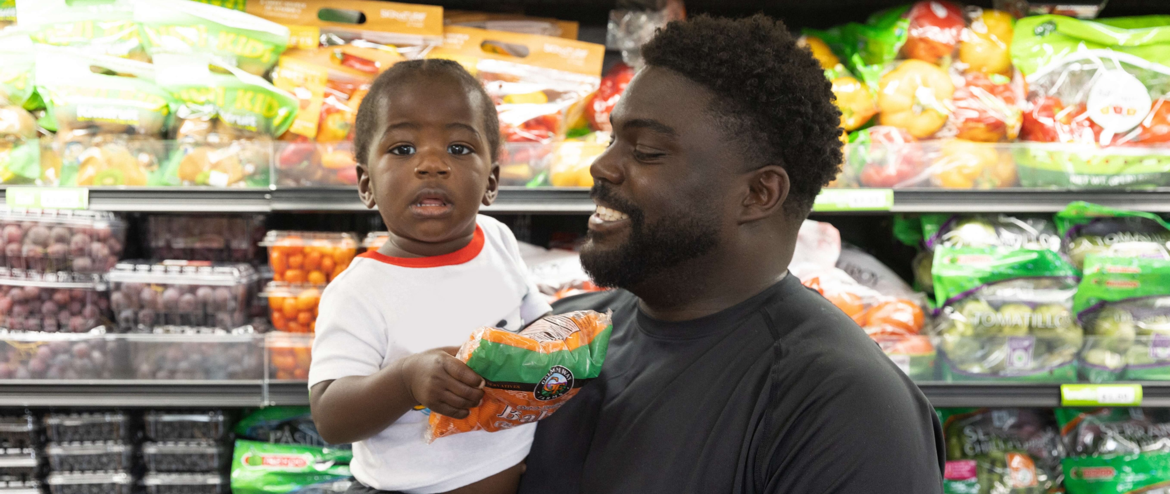 Dad holding child in grocery store