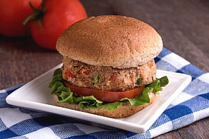 Tuna burger on a bun with lettuce and tomato