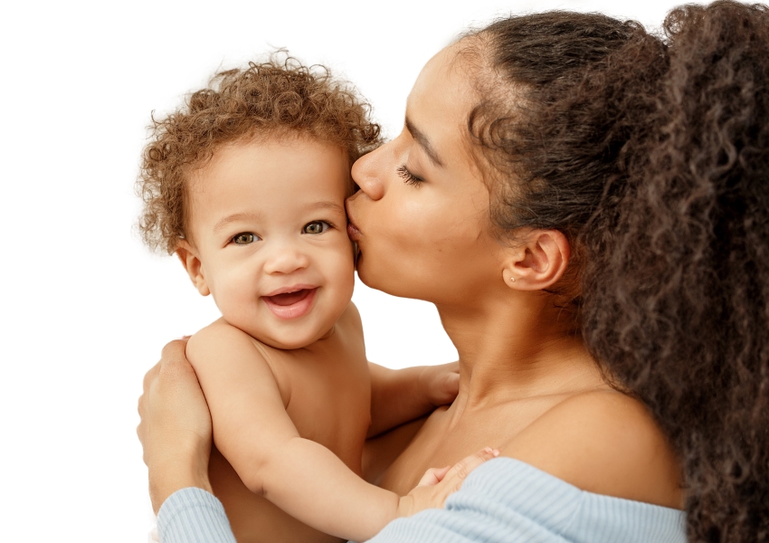a woman kissing her baby's head. 