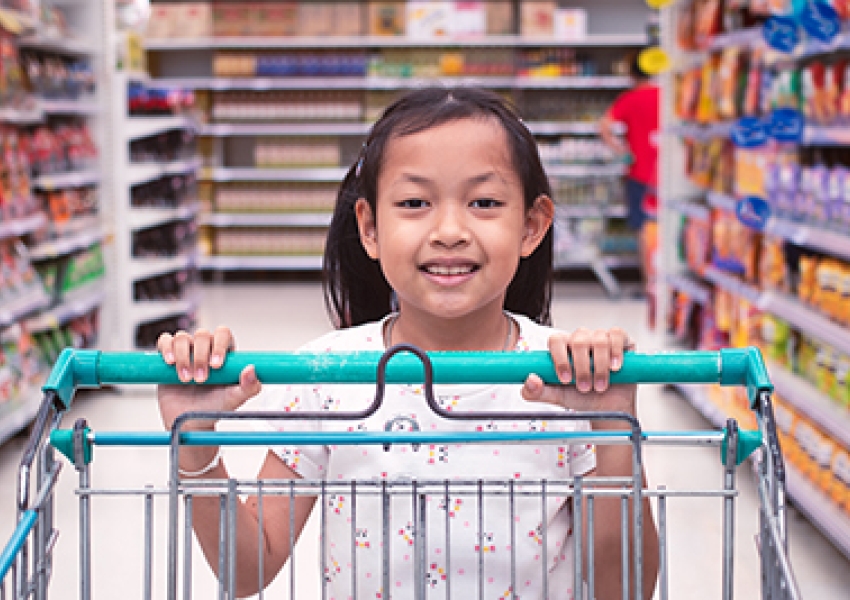 girl pushing a shopping cart in a grocery store