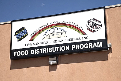 large sign on the side of the building for "Five Sandoval Indian Pueblos, Inc. Food Distribution Program"