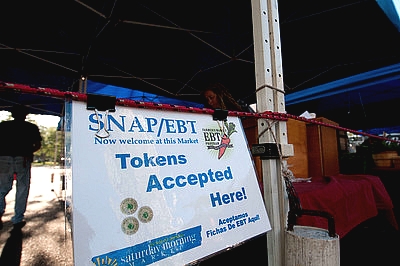 laminated sign on a farmers' market stand advertising SNAP/EBT welcome at this market