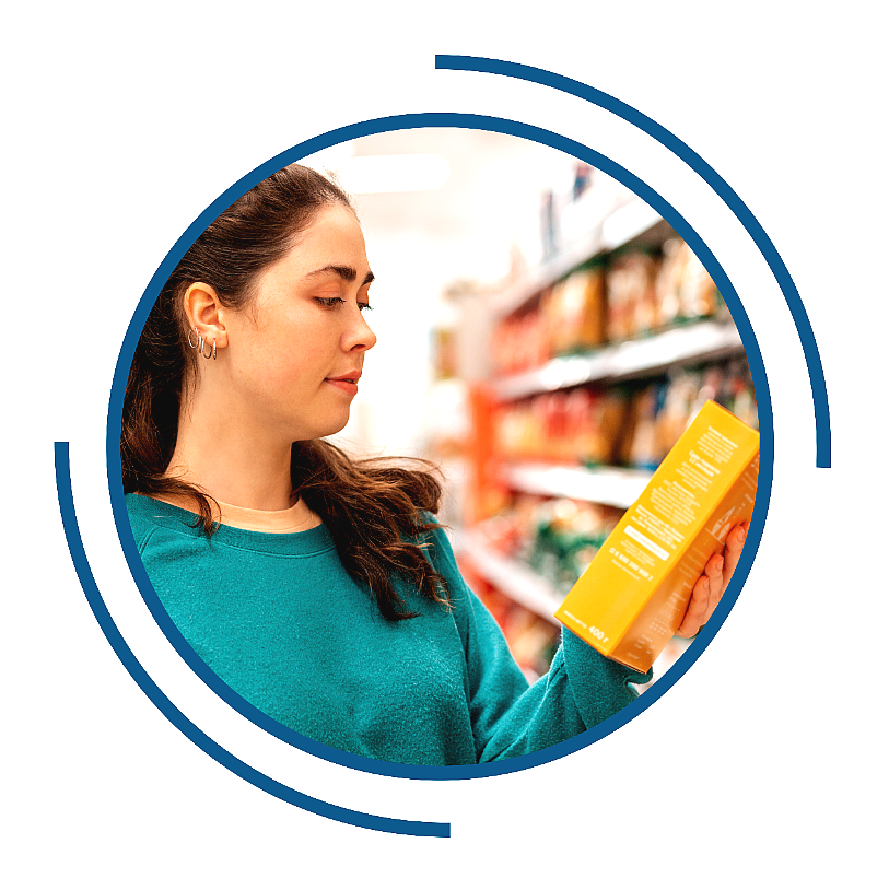 A woman reading the label of a food package at the grocery store.